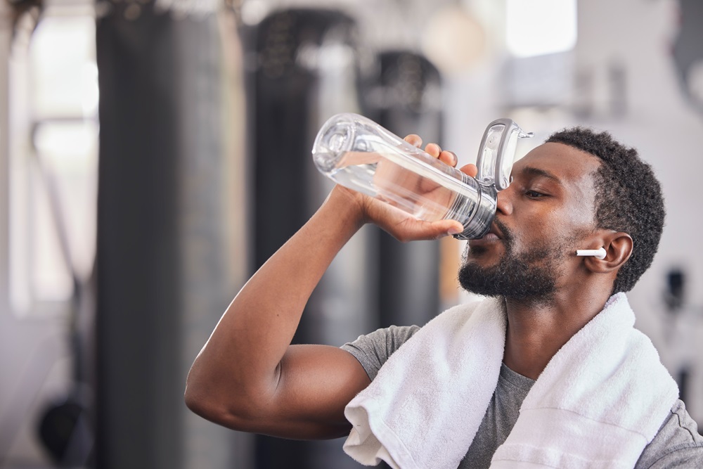 man drinking water at gym
